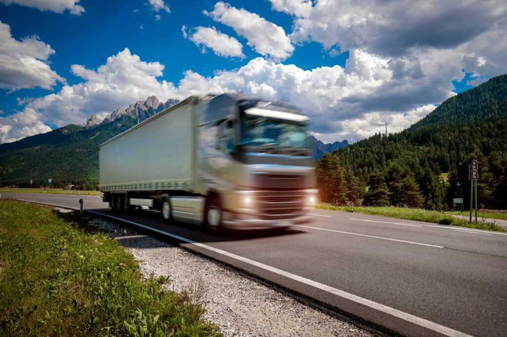 Fuel truck rushes down the highway in the background the Alps. Truck Car in motion blur.